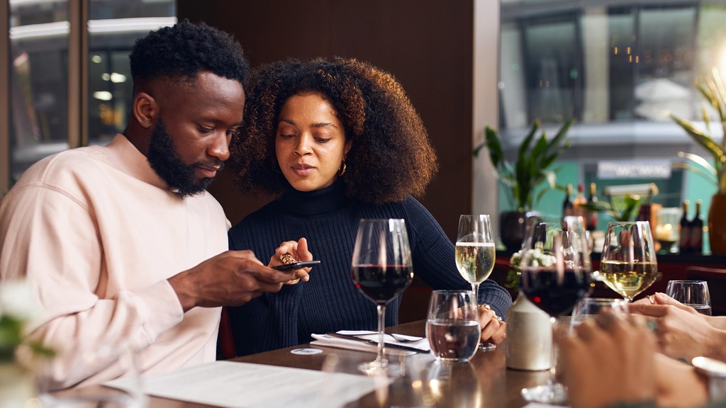 Couple looks at menu through QR code