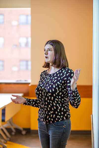 photo of Mary Beth Clarke giving a presentation to JWU classmates