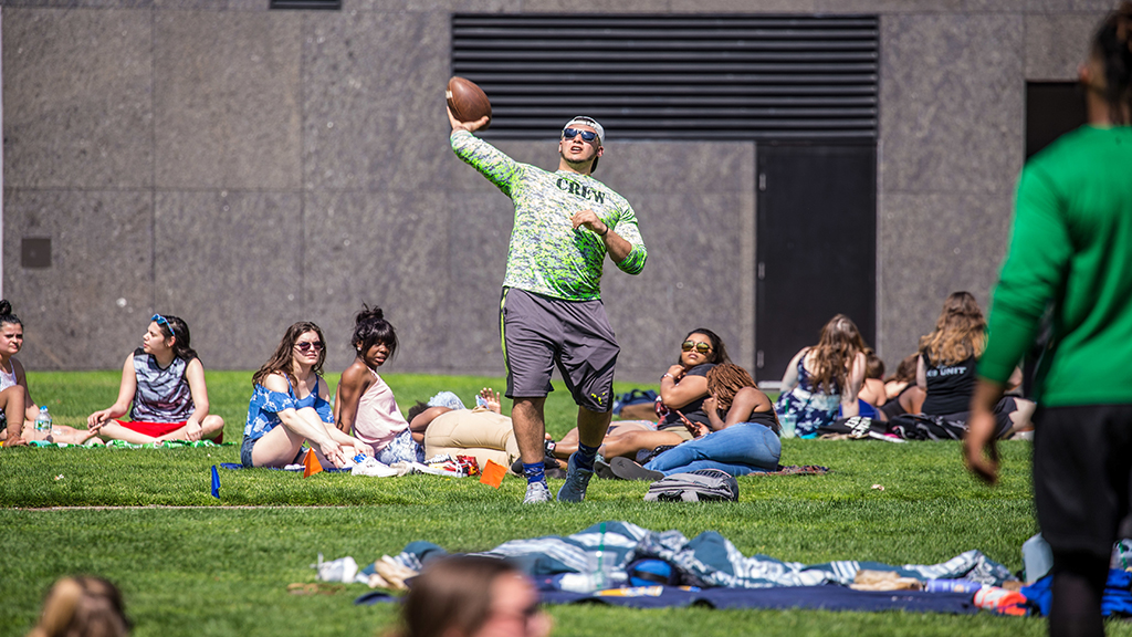 Students playing football and relaxing in Gaebe Commons