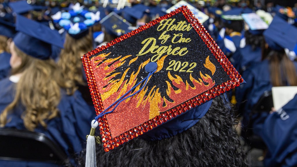 Decorated mortarboard that reads, “Hotter by One Degree, 2022.”