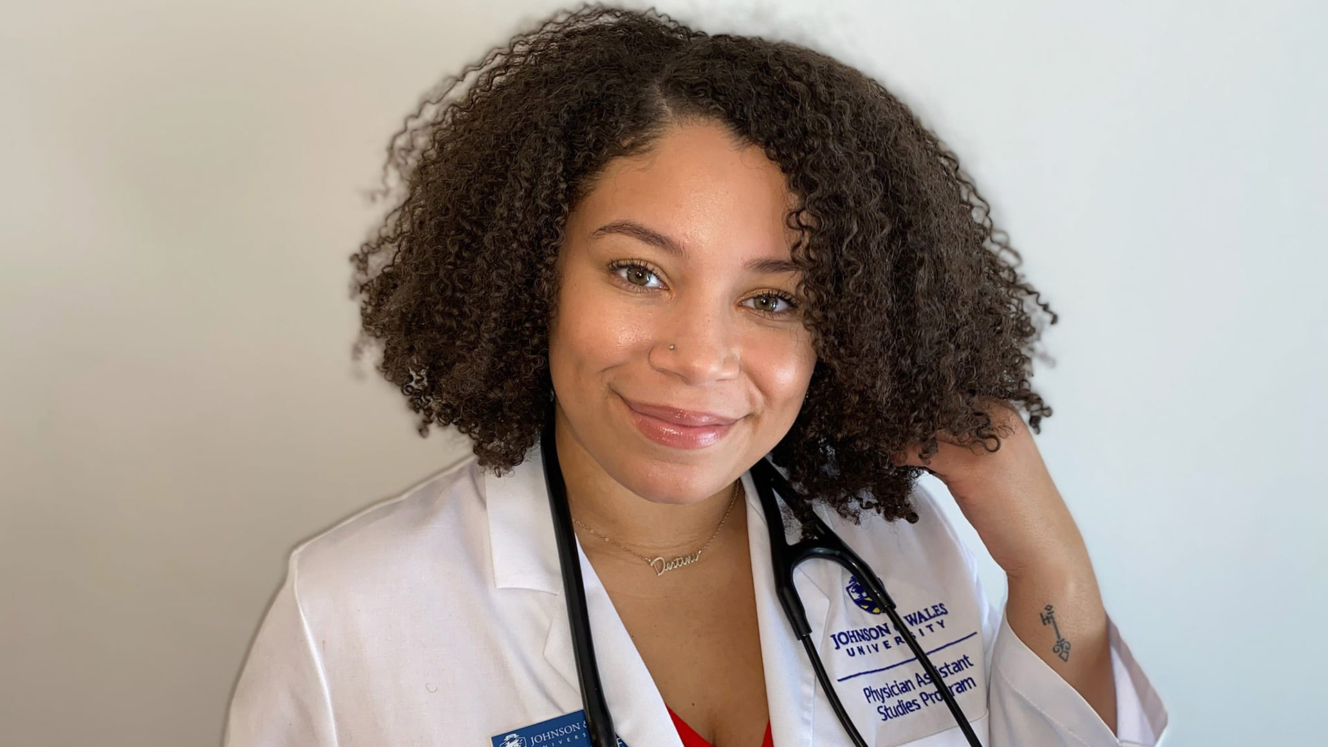 headshot of Destini Quinones in her JWU physician assistant white coat