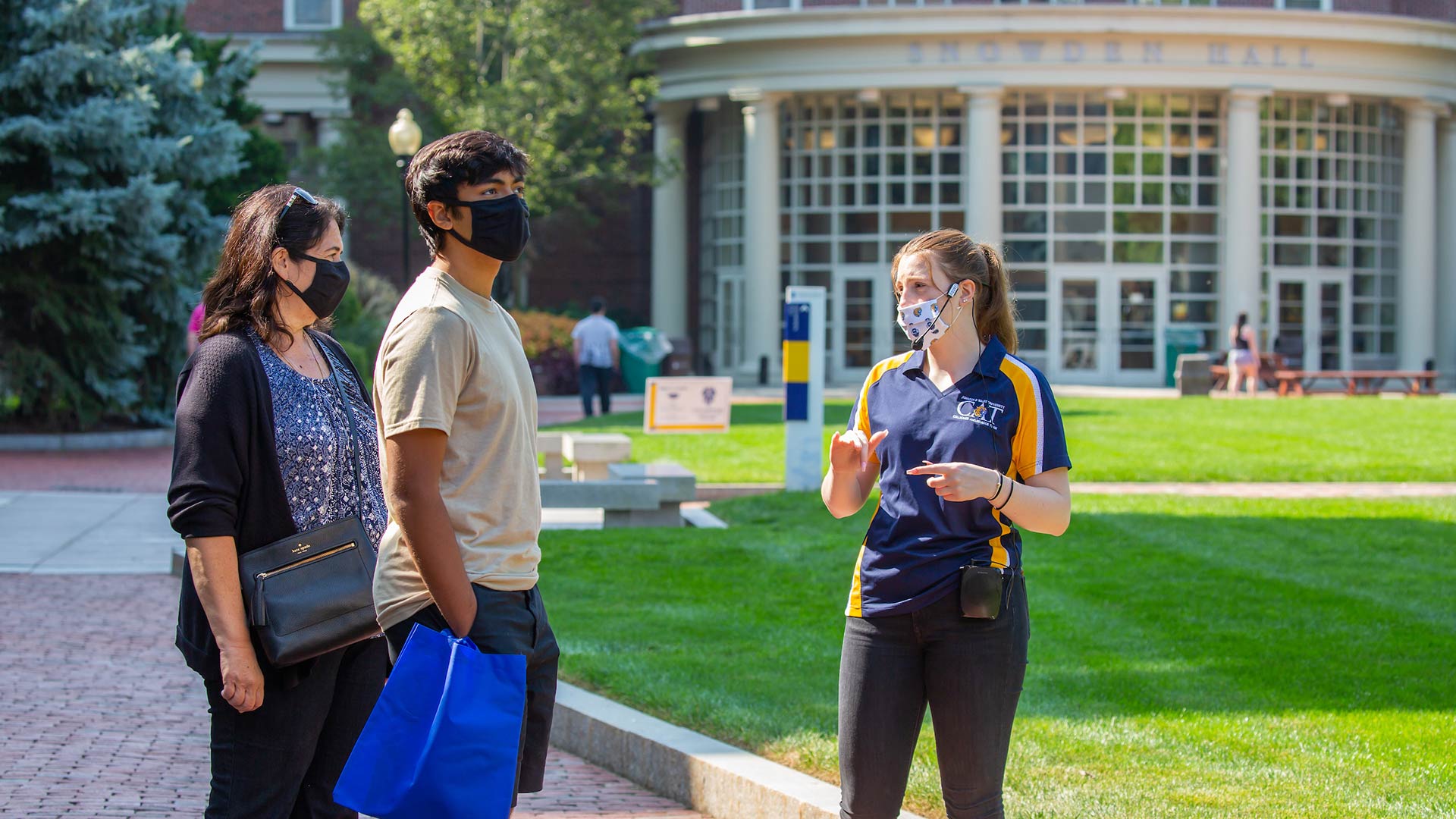 A JWU tour guide talking with a student and their parent