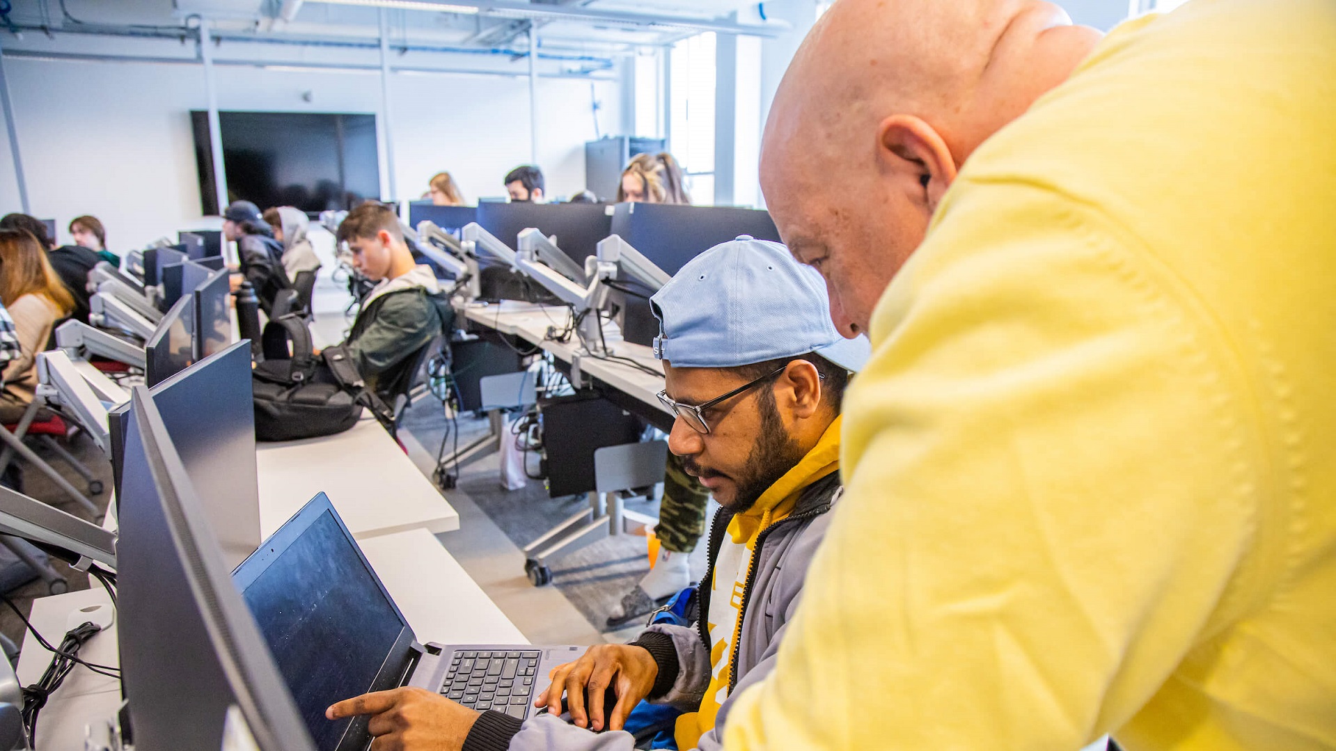 Professor helping students in computer lab