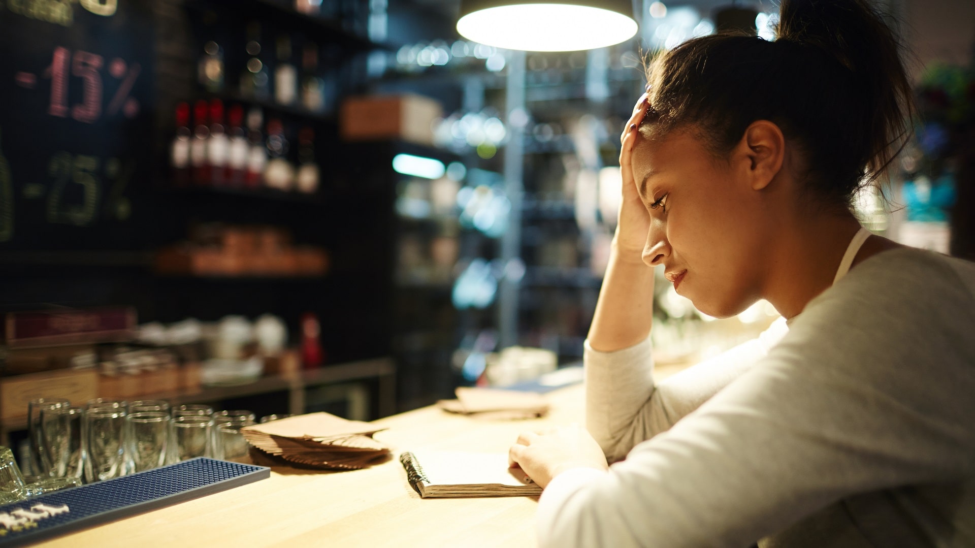 Woman in restaurant appears stressed at work