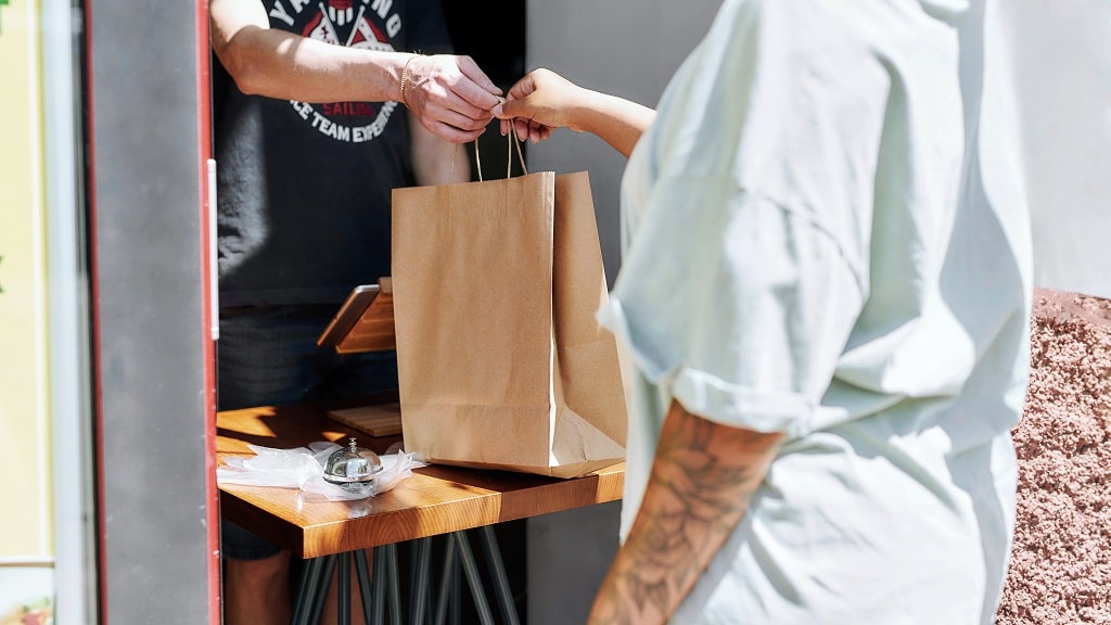 Customer picks up food at restaurant window