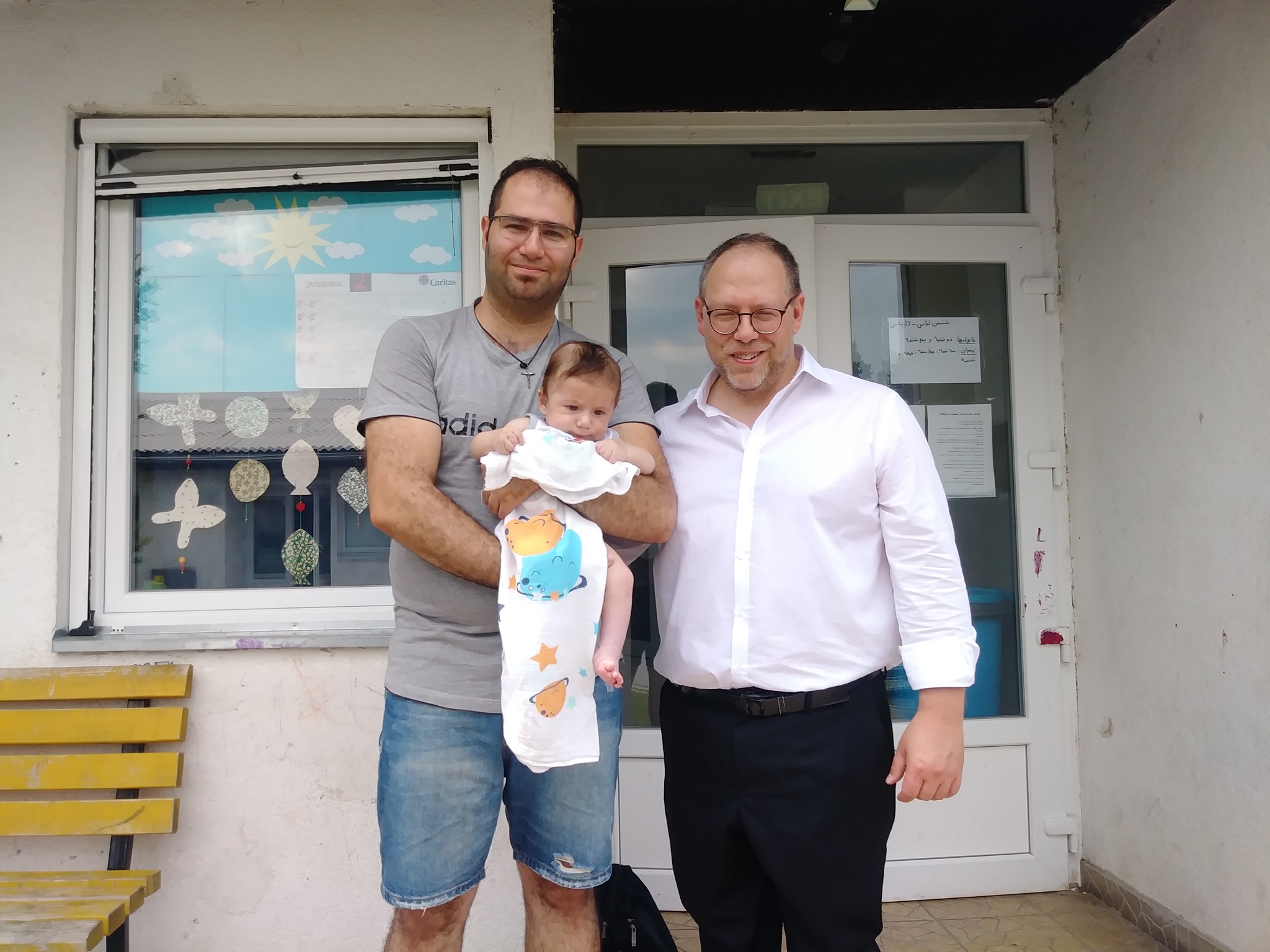 Associate Professor Kevin DeJesus with a displaced father and his newborn.