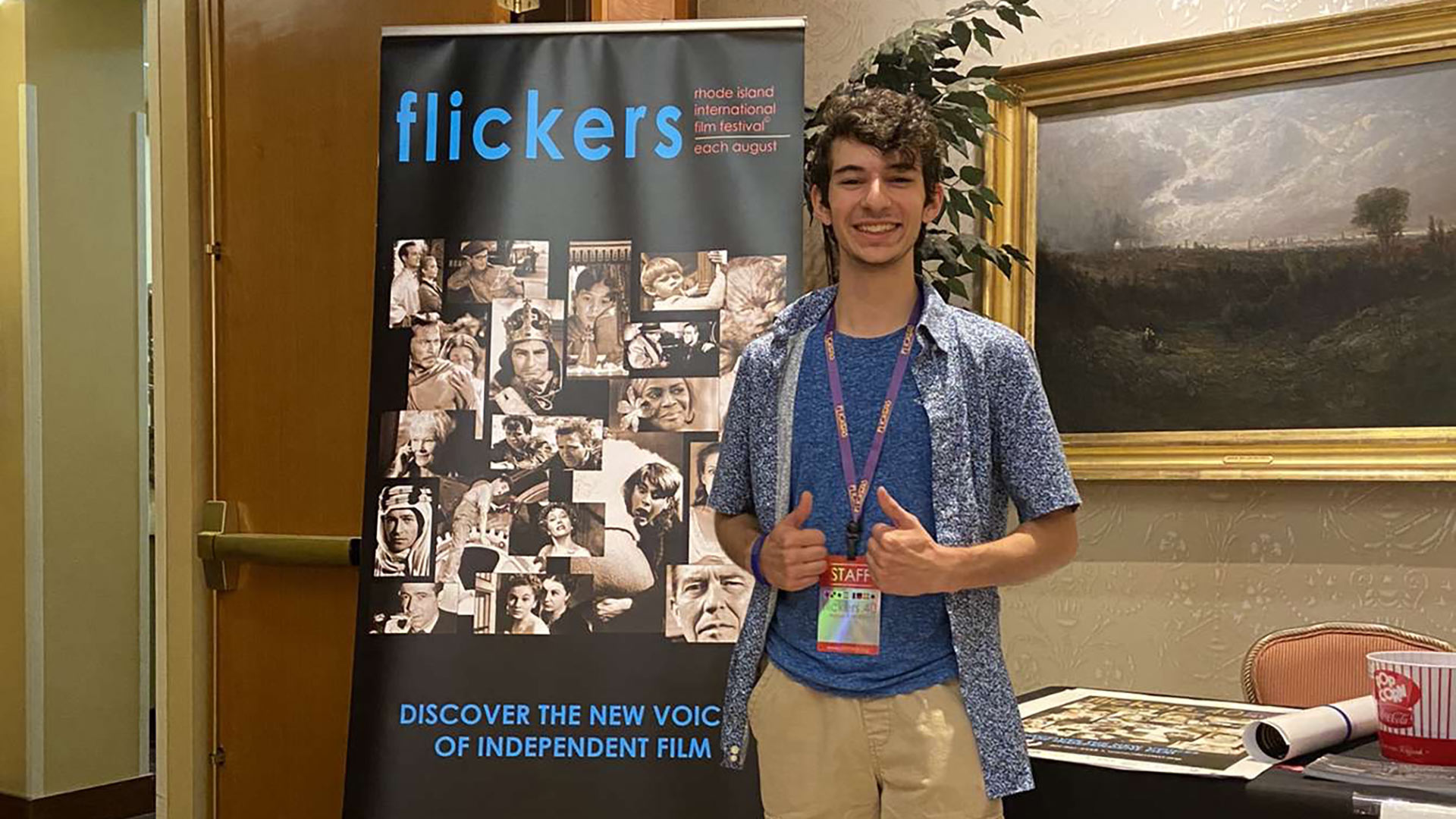 Student Trevor Emma standing in front of a Flickers banner at his internship
