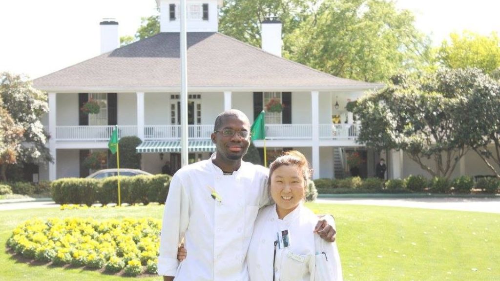 Two JWU students stand in front of Masters clubhouse