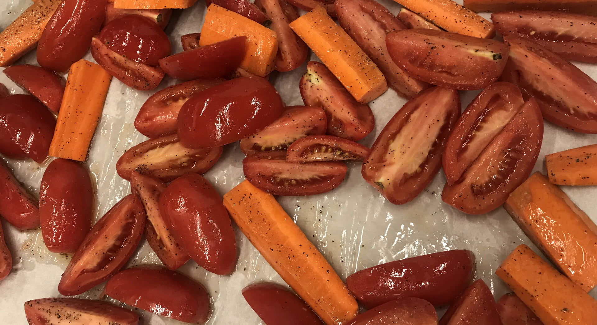 Seasoned tomatoes and carrots before going in the oven to roast.