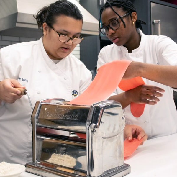 Meghan and Antoinnea roll out the pasta dough.