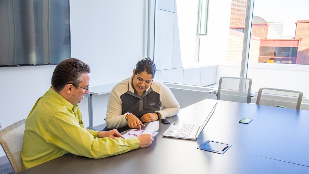 jwu student and professor looking over research