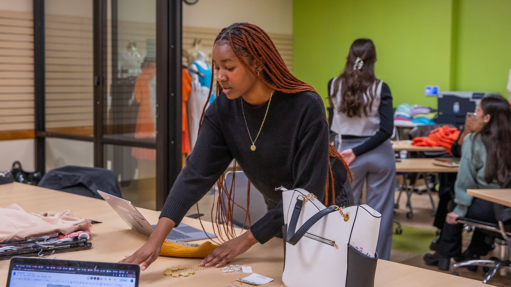 Zaharia Jones '24 looking at jewelry samples in the Retail Lab