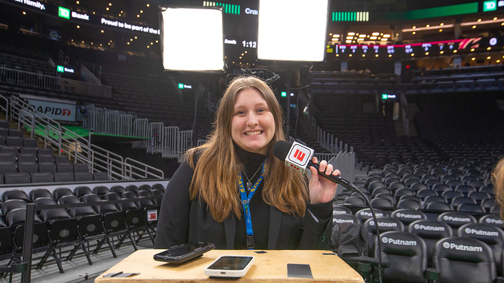 A student with a microphone and lights behind her at TD Garden