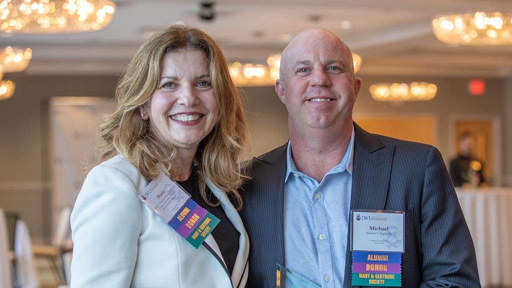 photo of JWU Providence Campus President Marie-Bernardo-Sousa posing with Outstanding Achievement Award winner Michael Rypka '96