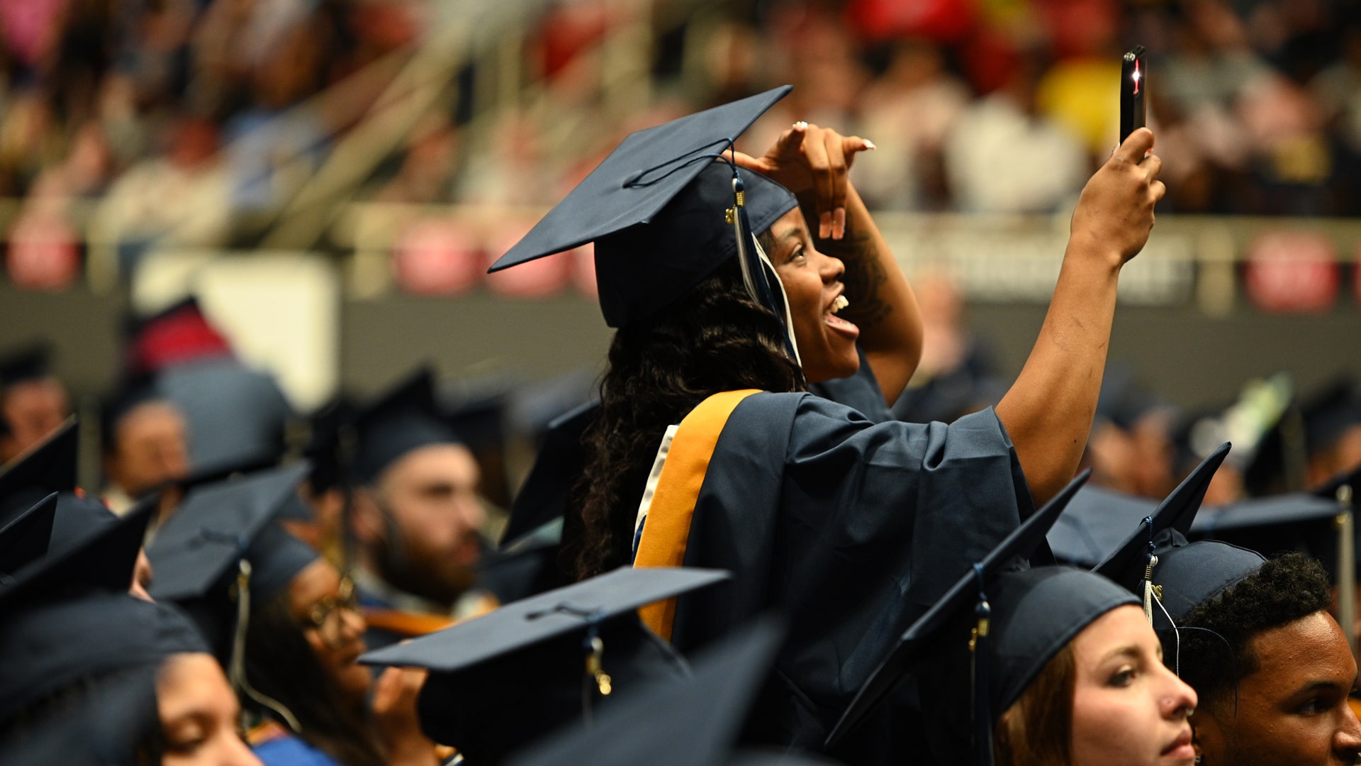 Charlotte grad taking a photo of the crowd with her iPhone.