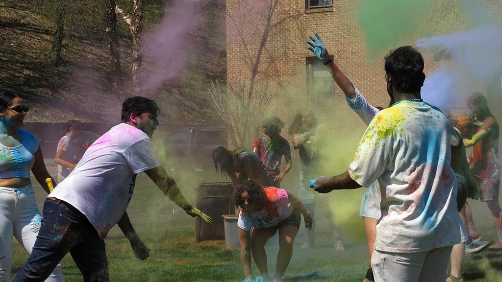 students throwing colored chalk powder at Holi