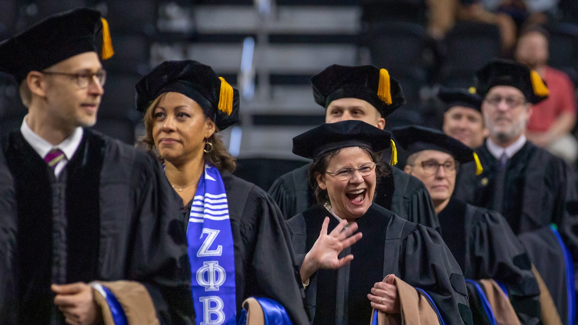 New grad waving as she walks in the procession.