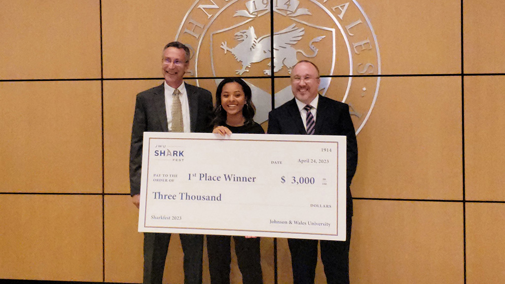 Aneelia Ma holding her winner's check with her professors standing with her