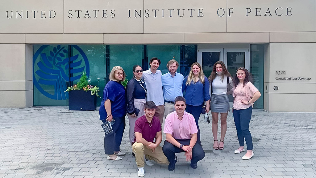 A group of JWU students posing in front of the United States Institute of Peace