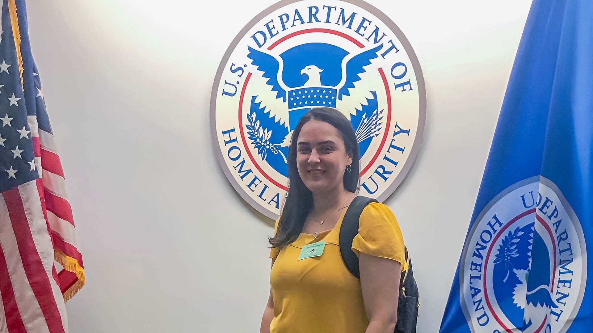 JWU student Jazmin Pacheco standing in front of US Department of Homeland Security logo