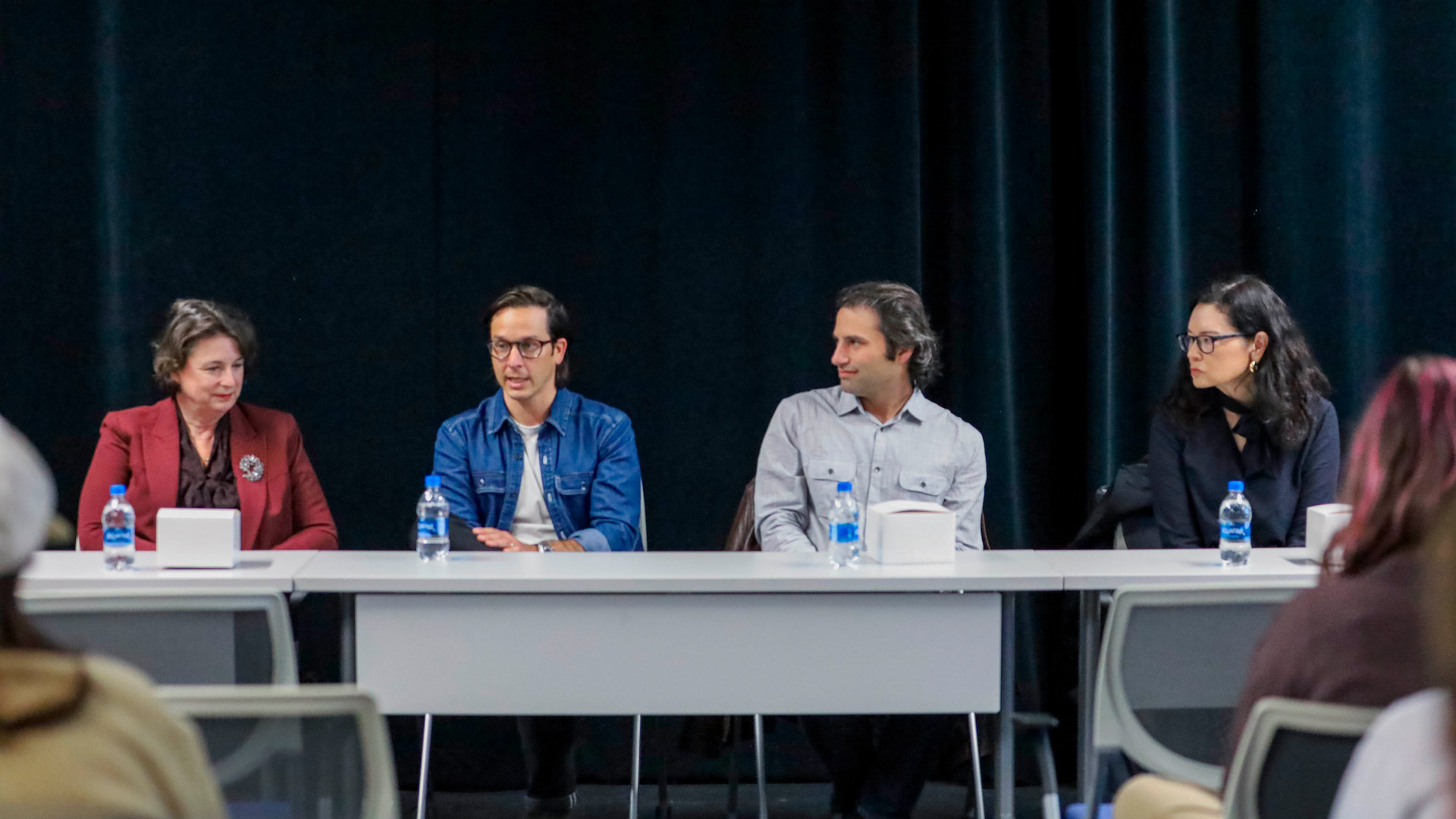 Career professionals sitting along a table at a panel session.