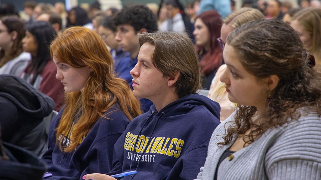 a photo of JWU students in an audience listening to a VIP lecture