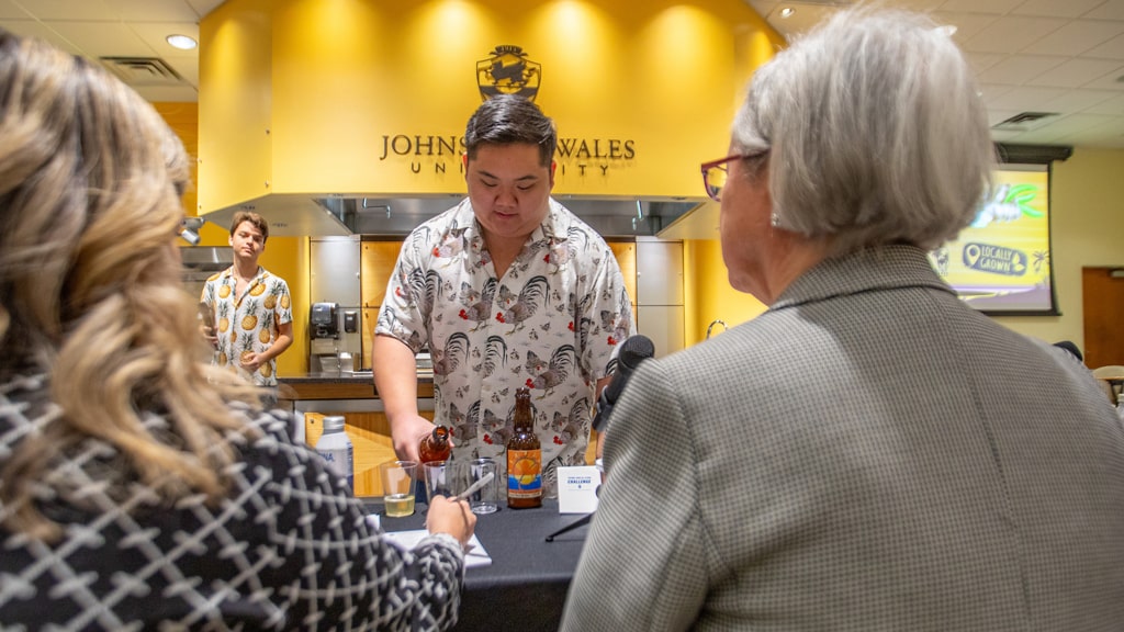 Spencer Mah (foreground) and John Owen (background) offer samples of their Island Girl ginger beer to the judges.