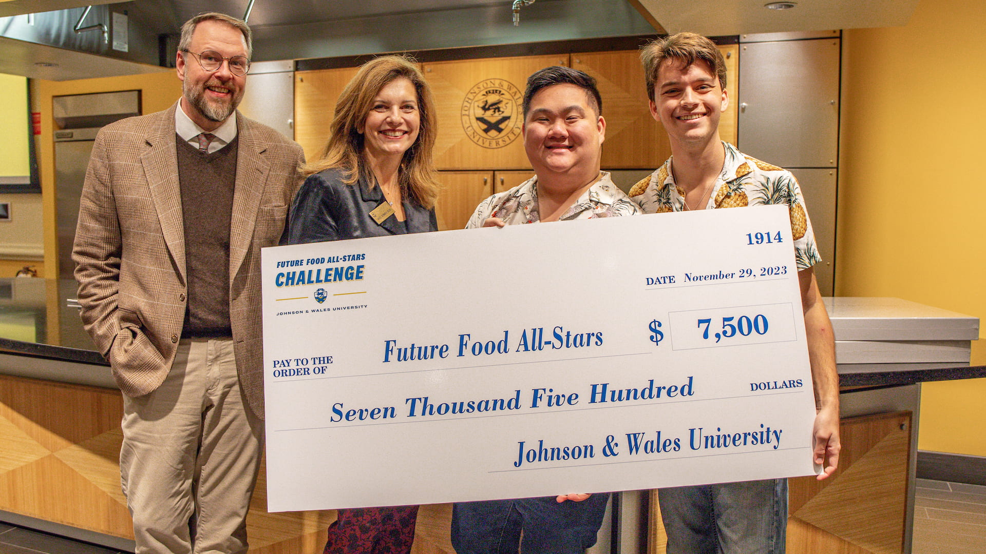 Spencer Mah and John Owen (right) with CFIT Dean Evans and JWU Providence Campus President Bernardo-Sousa (left) and the winning check.
