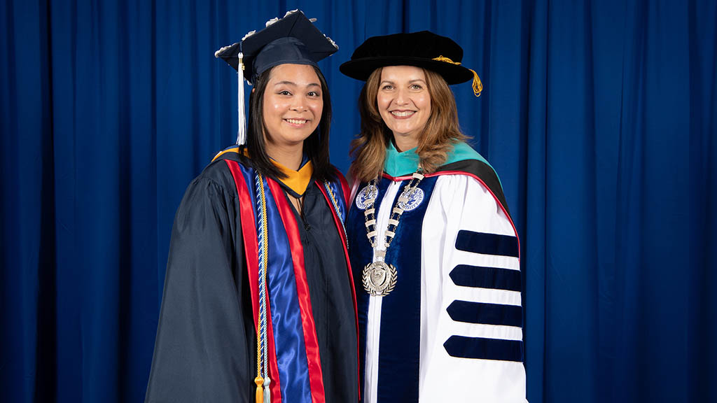Hillary Thilavong '23 and JWU Providence Campus President Marie Bernardo-Sousa pose for a photo at Commencement 2023