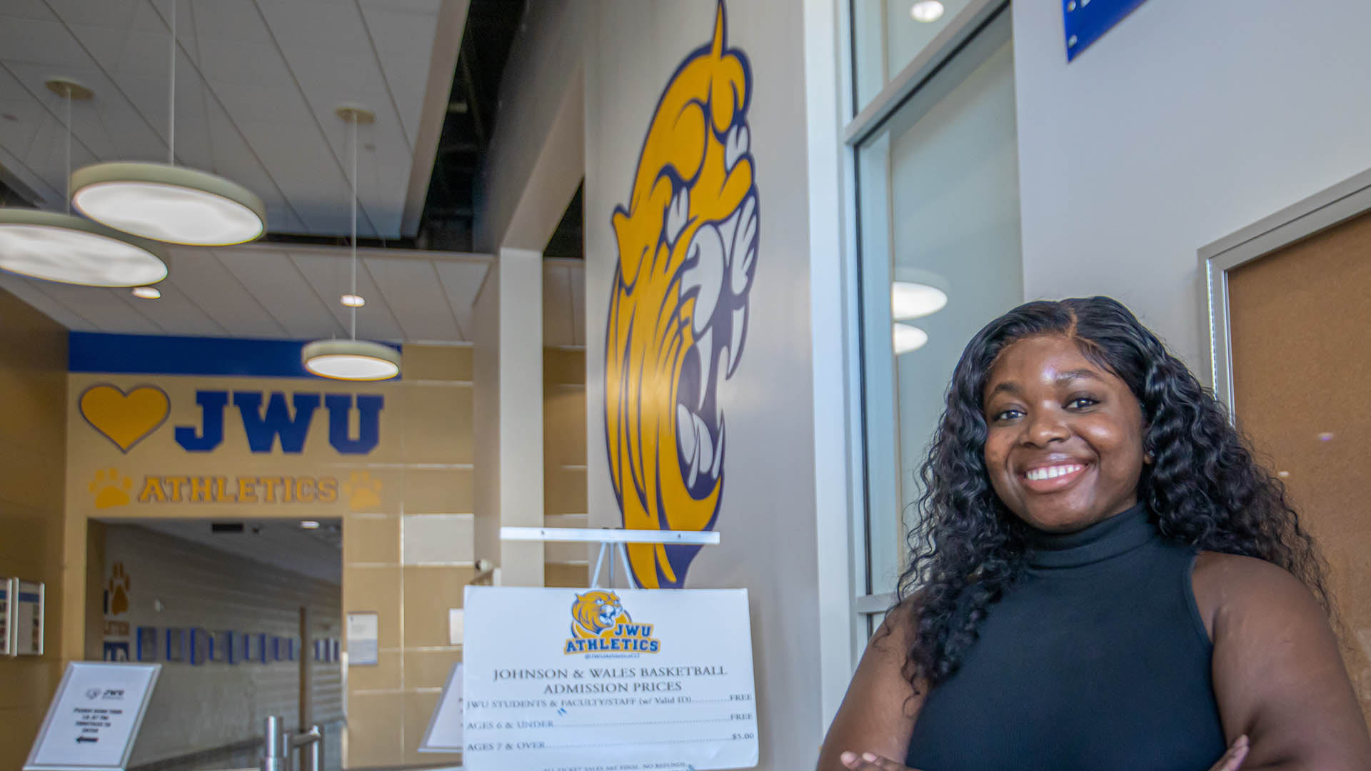 a banner photo of Vanessa Beke '23 posing in the lobby of JWU's Wildcat Center