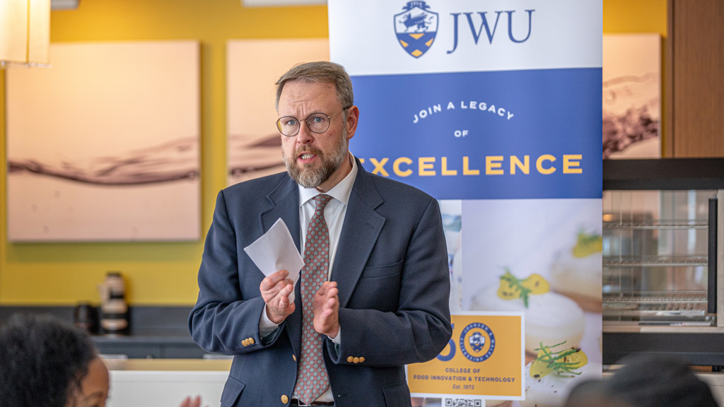 an action shot of CFIT Dean Jason Evans speaking to a room of people