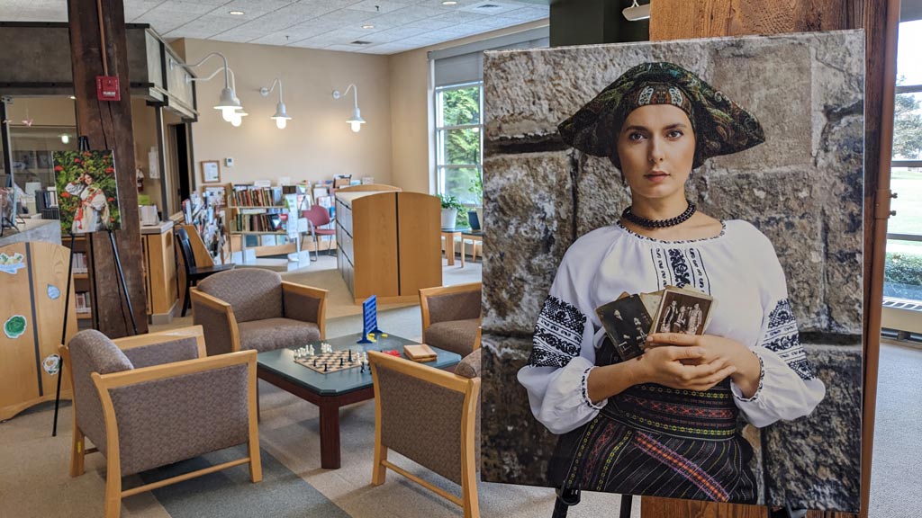 photo of a displayed art exhibit in the forefront of JWU's Harborside Campus library