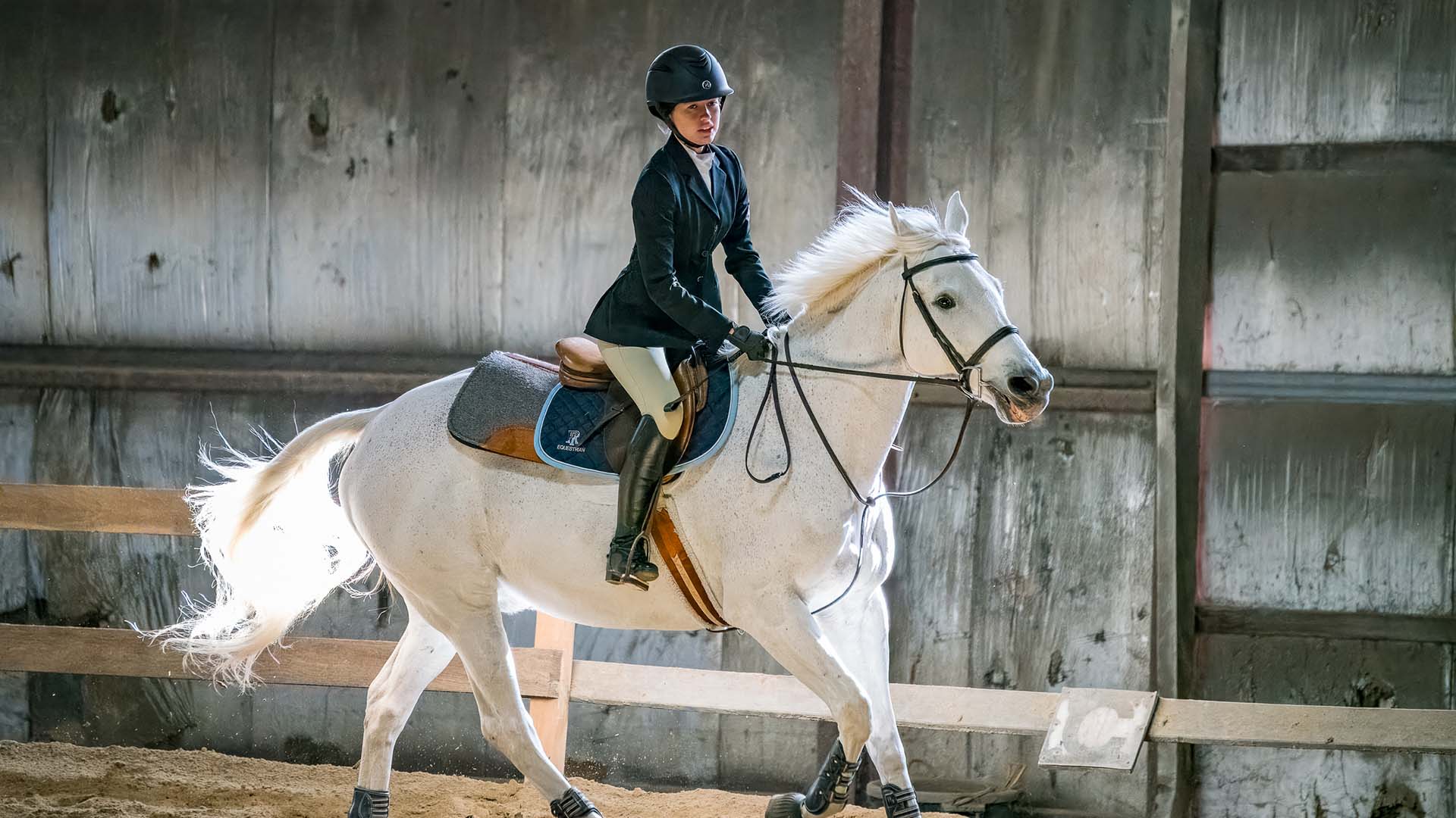 Julia Shiels riding a white horse for the JWU IHSA team.