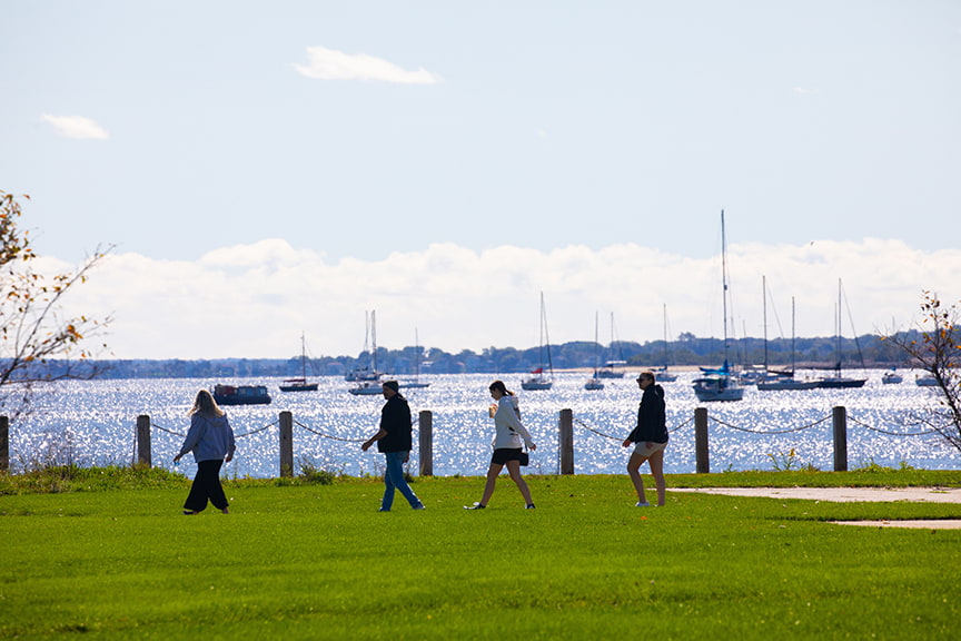 A family walks by the bay at the Harborside Campus