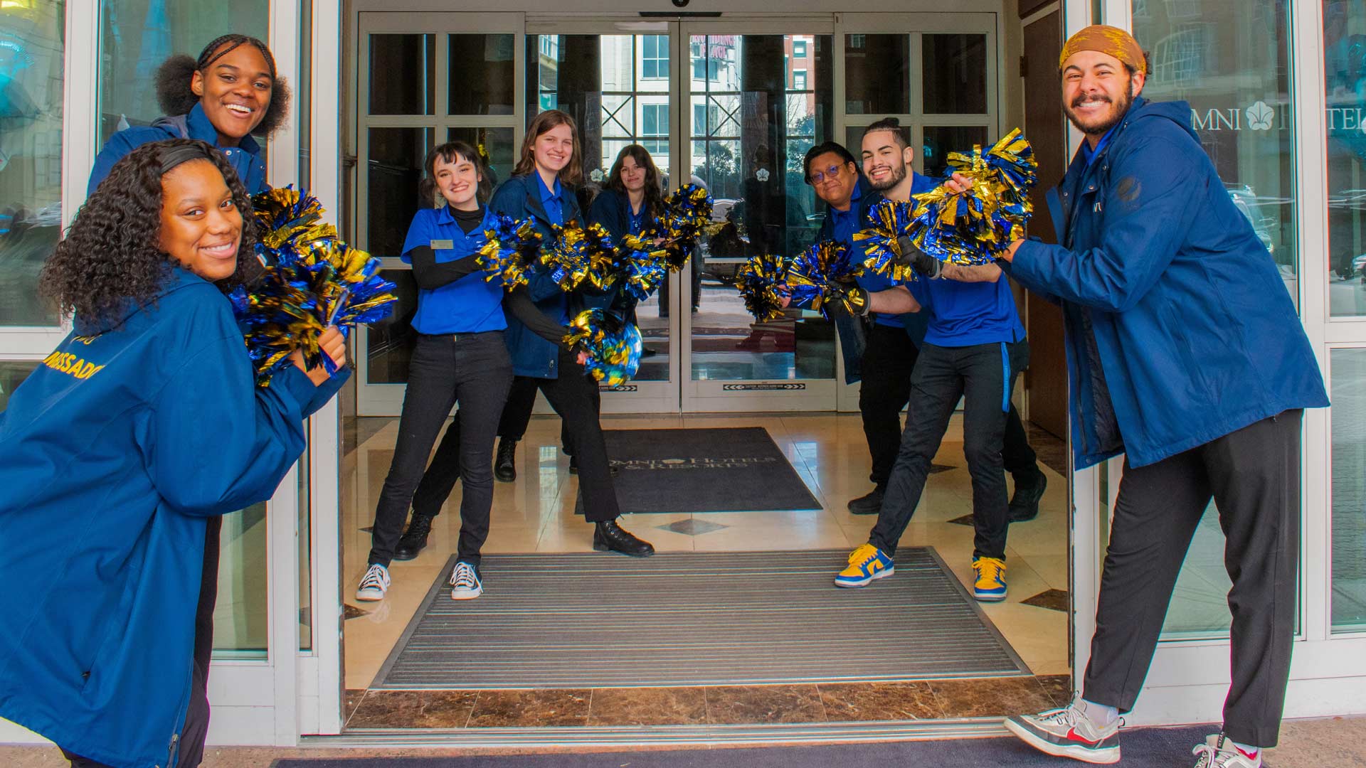 a photo showing CAT ambassadors lining the way welcoming a new student to JWU
