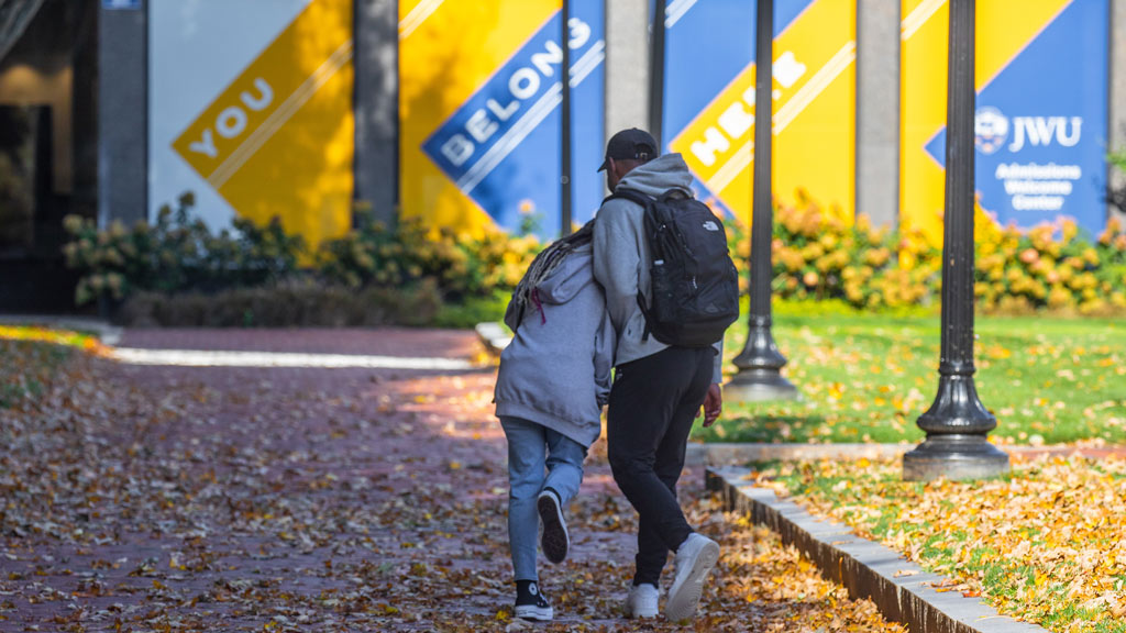 photo of the backs of two students walking on JWU's Providence Campus