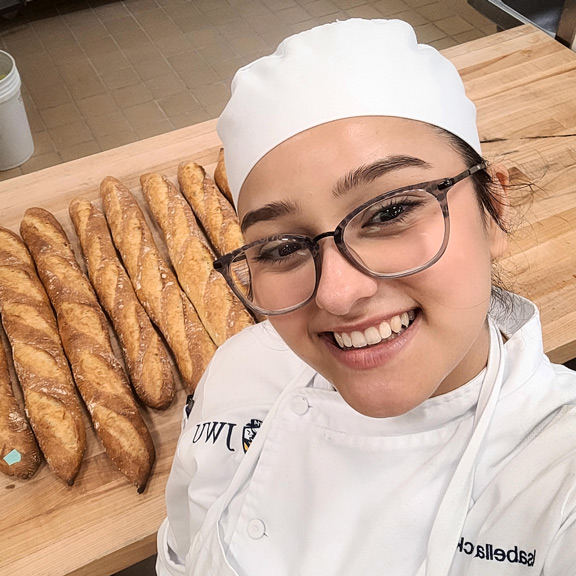 photo of Isabella Mock '27 posing with bread she's baked