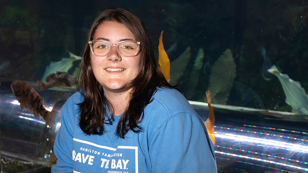 Hailey Sangillo '27, in front of aquarium tank