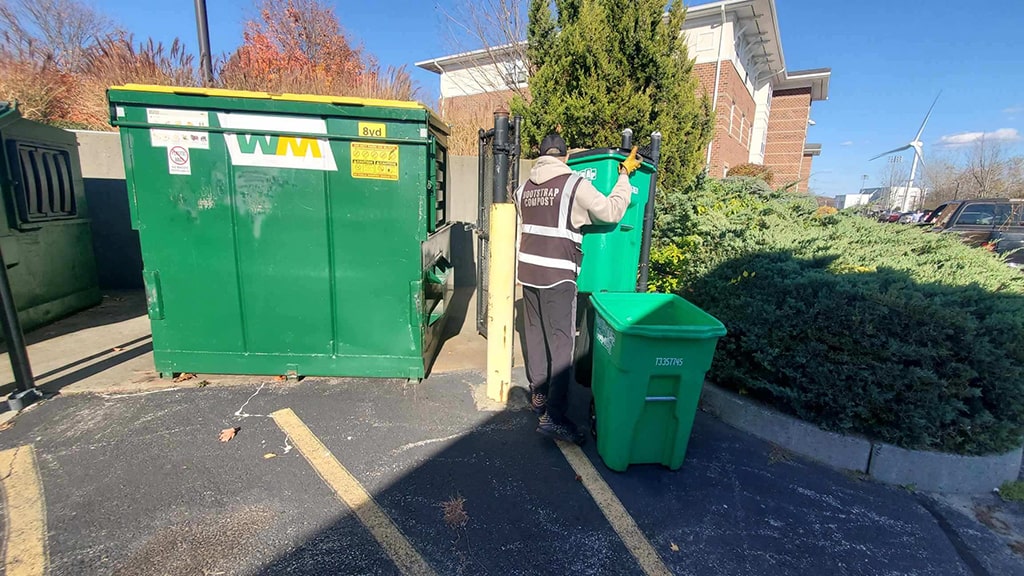 Bootstrap Compost worker picks compost bucket up at Harbor View