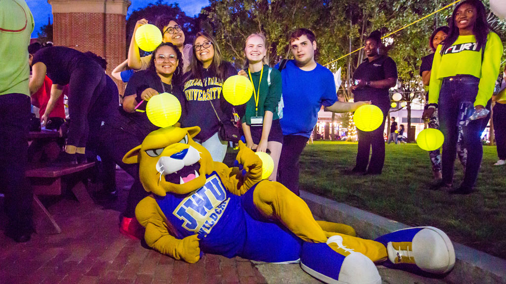 photo of Willie the Wildcat posing with a group of JWU students