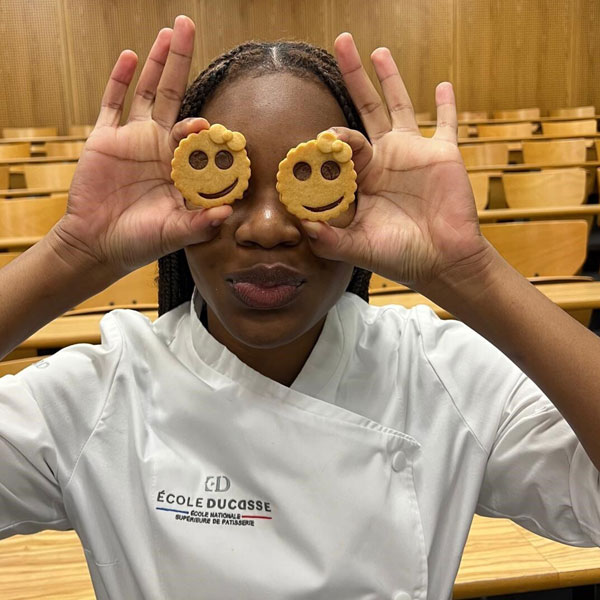 Zoé Rodgers holds up her smiling cookie creations.