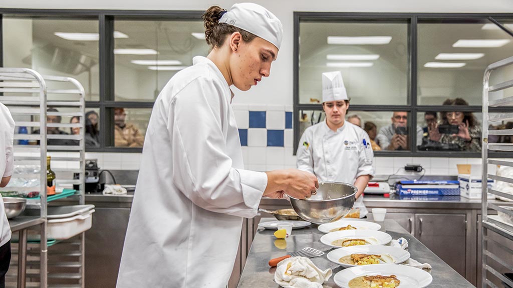Logal Vidal plates his red snapper dish in the JWU Charlotte culinary lab.