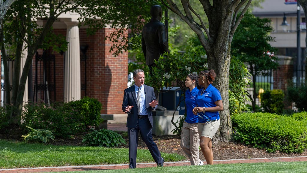photo of President Joseph Greene and two students walking on Gaebe Commons