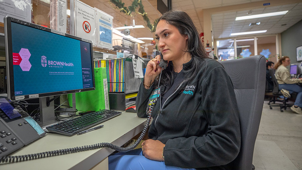 Aria Coutu '26 speaks on the phone at her Brown Health internship