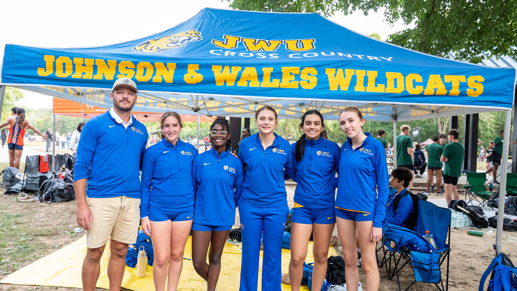 Head Coach Dustin Stewart, far left, poses with the JWU Charlotte Women’s Cross-Country team at their October race.