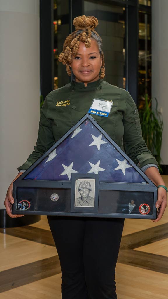 Gillian Howard holding an American flag and picture of herself