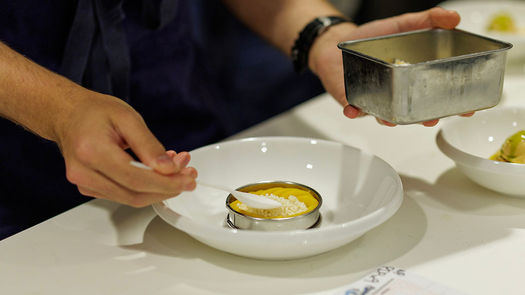 Close-up of Daron Sklar plating a fruit dessert at The Modern.