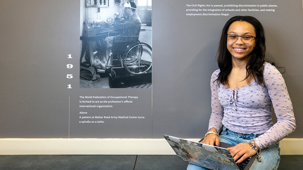 Cora Hicks '27 smiles while holding her laptop