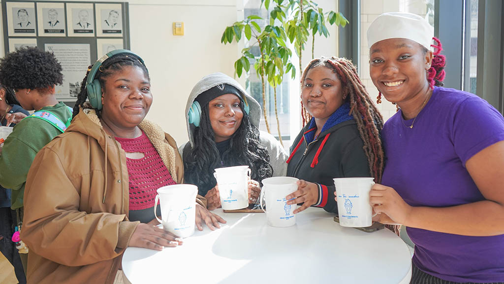 Students in the University Events Center with ice cream buckets.
