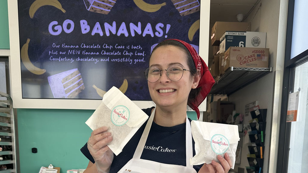 Jamie Kluger '26 at SusieCakes holding up some cookies in bags